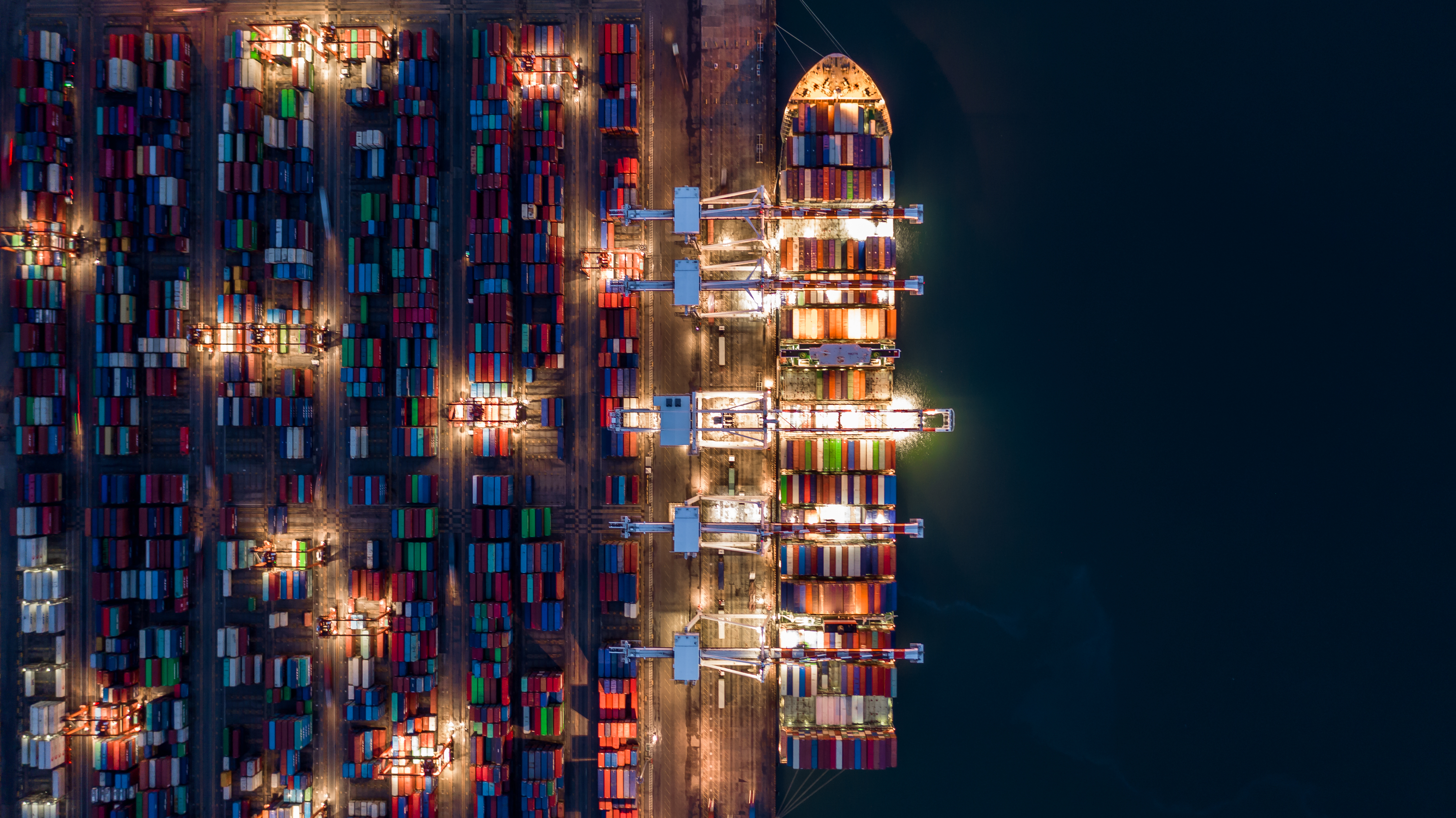 Crane shipping container at night Aerial top view container ship carrying container import and export business logistic and transportation 1082441170 5193x2918